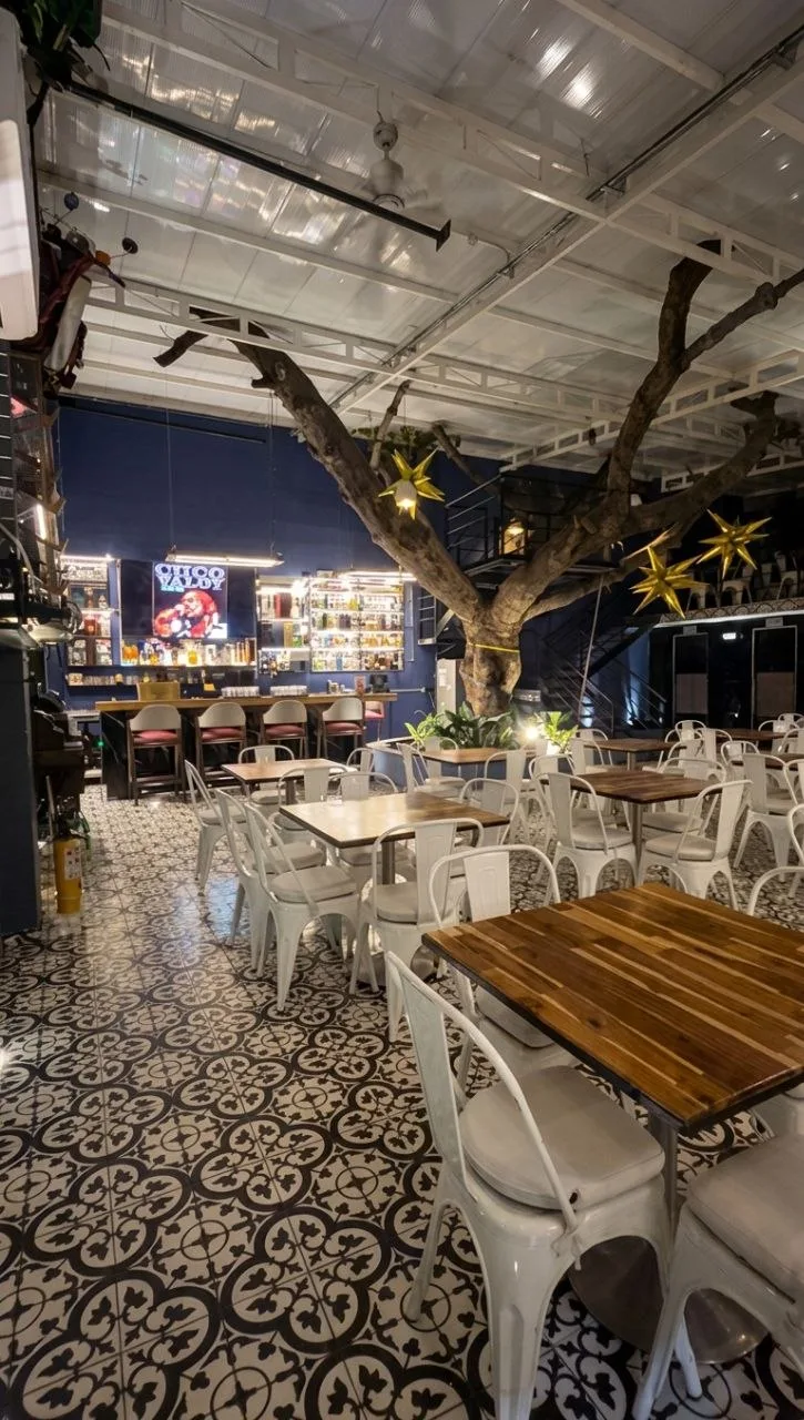 Salón Museo: árbol centenario con estrellas doradas, barra azul y piso de mártides