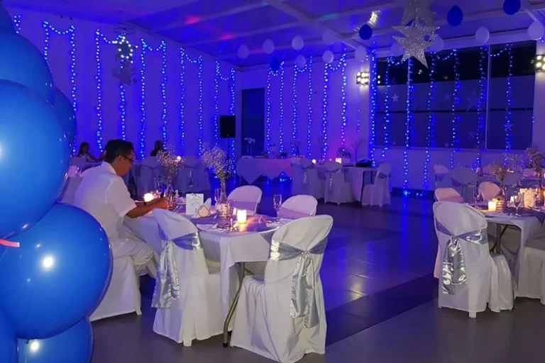 Salón principal con sillas blancas y cintas doradas para evento